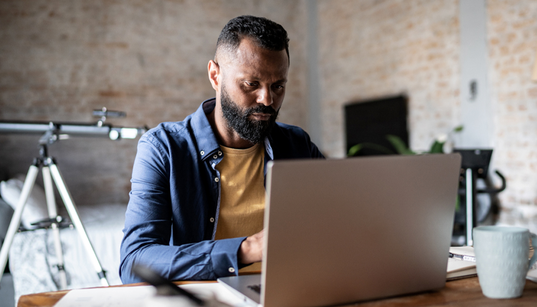 casually dressed man working on laptop